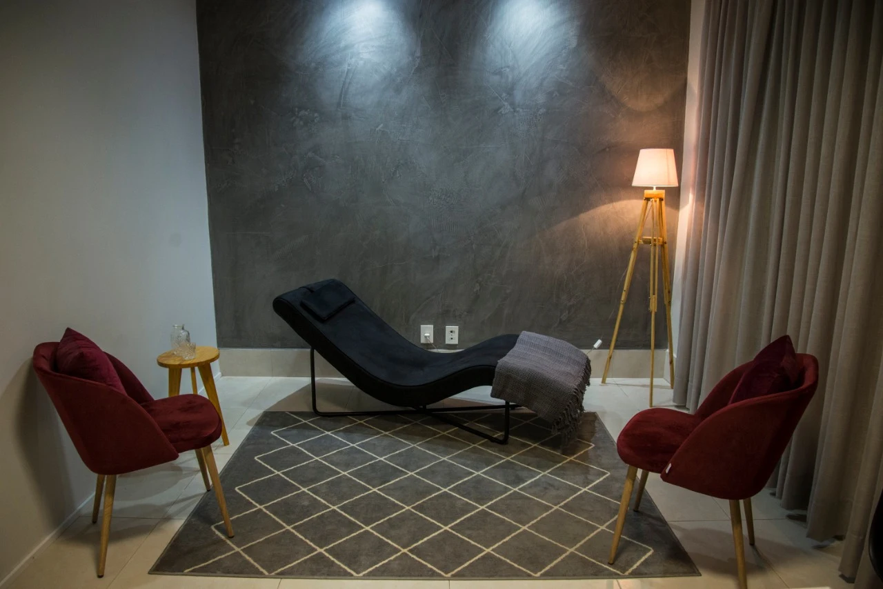 Consultório acolhedor da Clínica NOUS com divã e poltronas